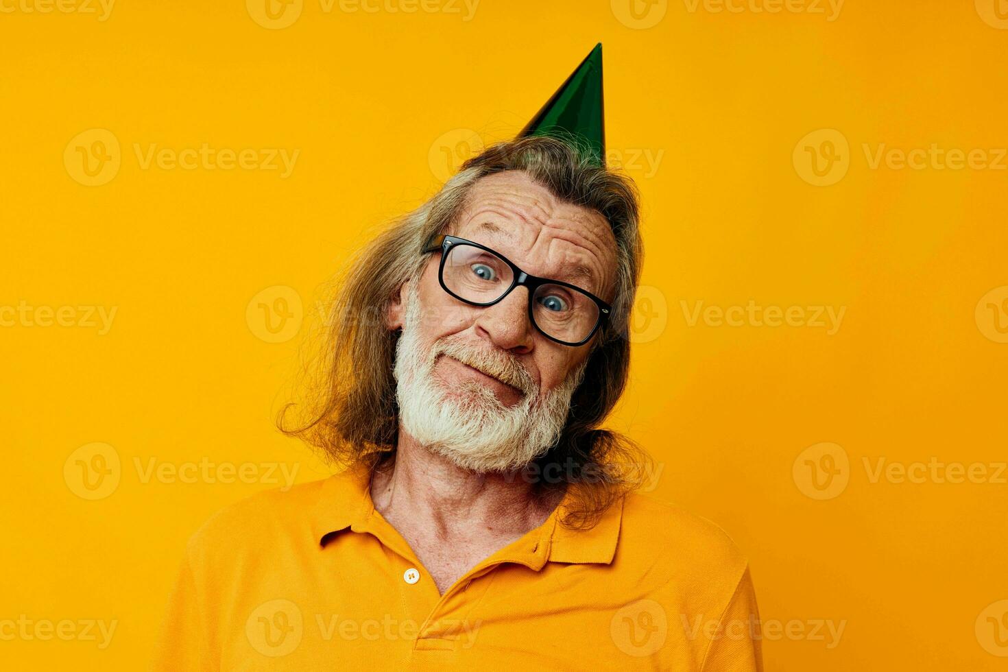 Portrait of happy senior man in a yellow t-shirt with a cap on his head fun yellow background photo