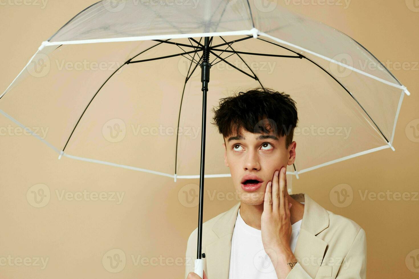 photo of a young guy in a white jacket with an open umbrella