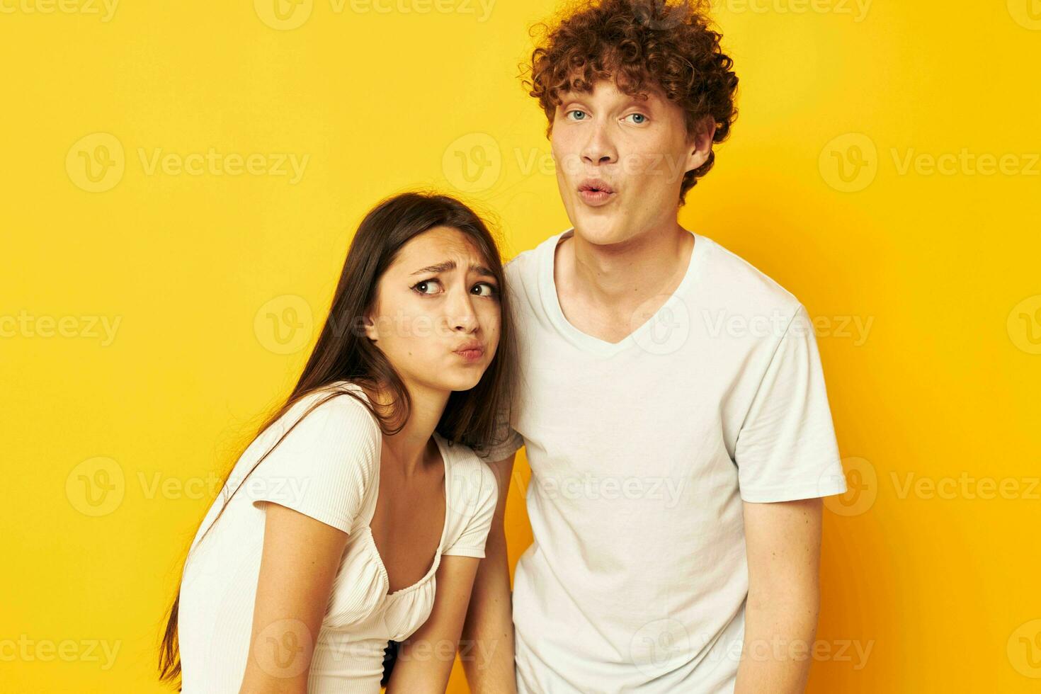 cute young couple standing side by side in white t-shirts posing Lifestyle unaltered photo