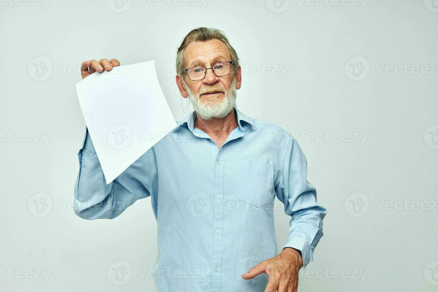 elderly man holding a sheet of paper copy-space posing isolated background photo