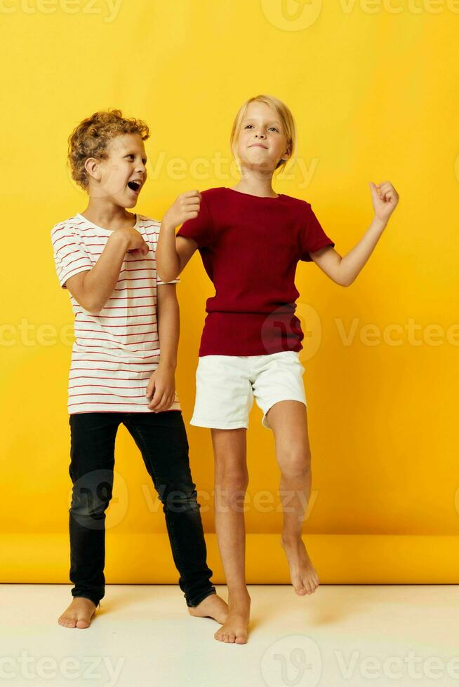 dos alegre niños en pie lado por lado posando infancia emociones aislado antecedentes foto