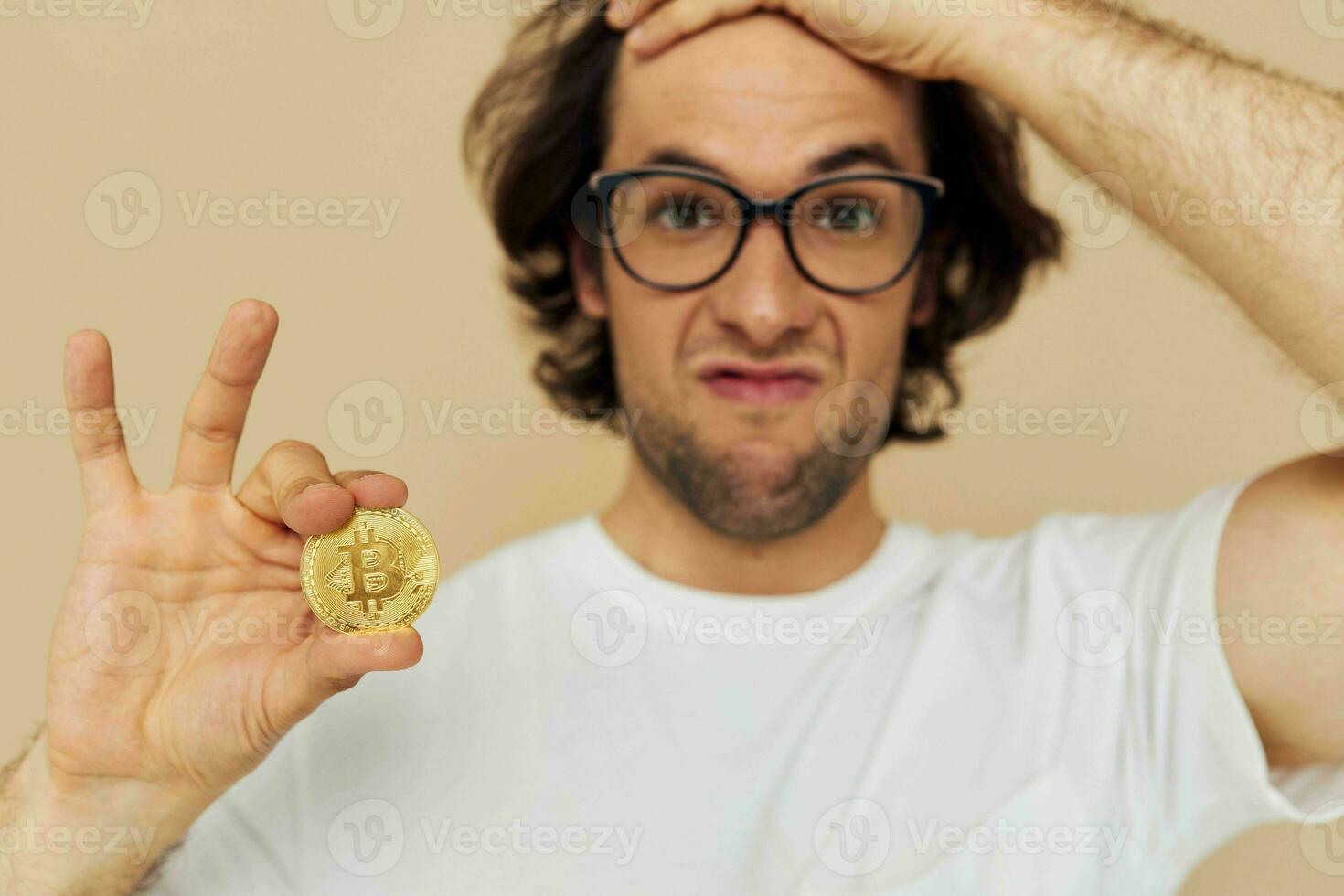 Cheerful man in a white T-shirt with Bitcoin cryptocurrency beige background photo
