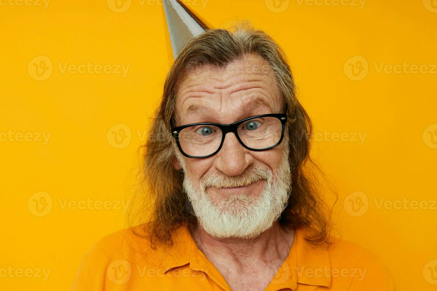 cheerful elderly man in glasses with a cap on his head yellow background photo