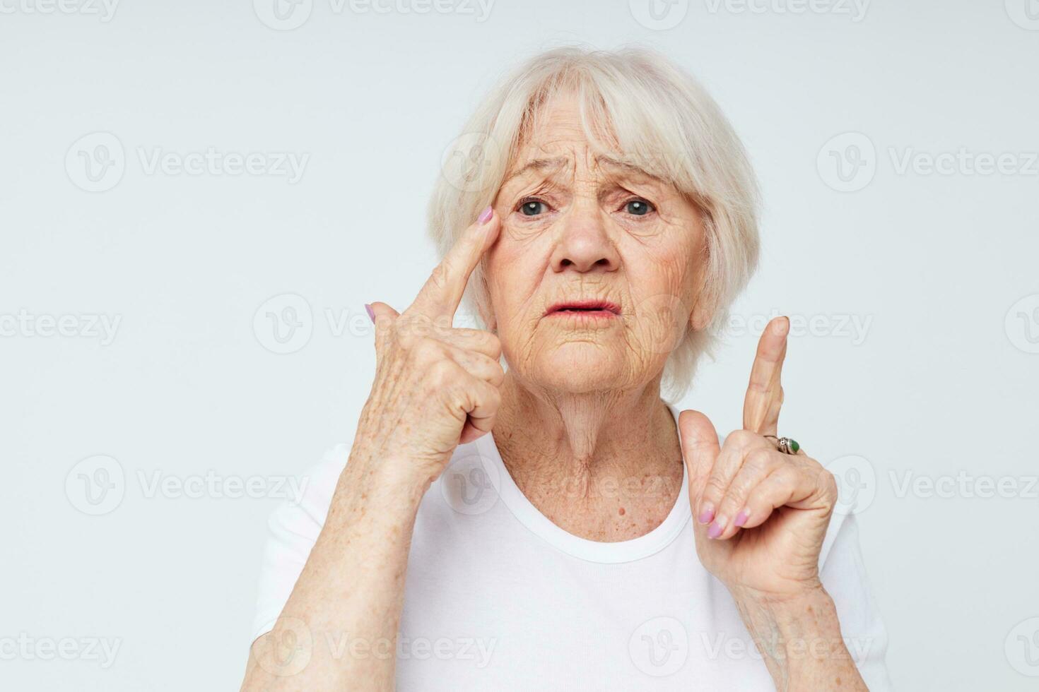 Portrait of an old friendly woman vision problems myopia light background photo