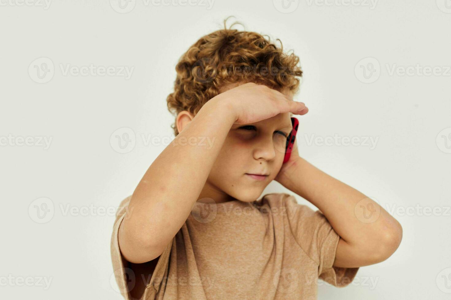 funny curly boy talking on the phone light background photo