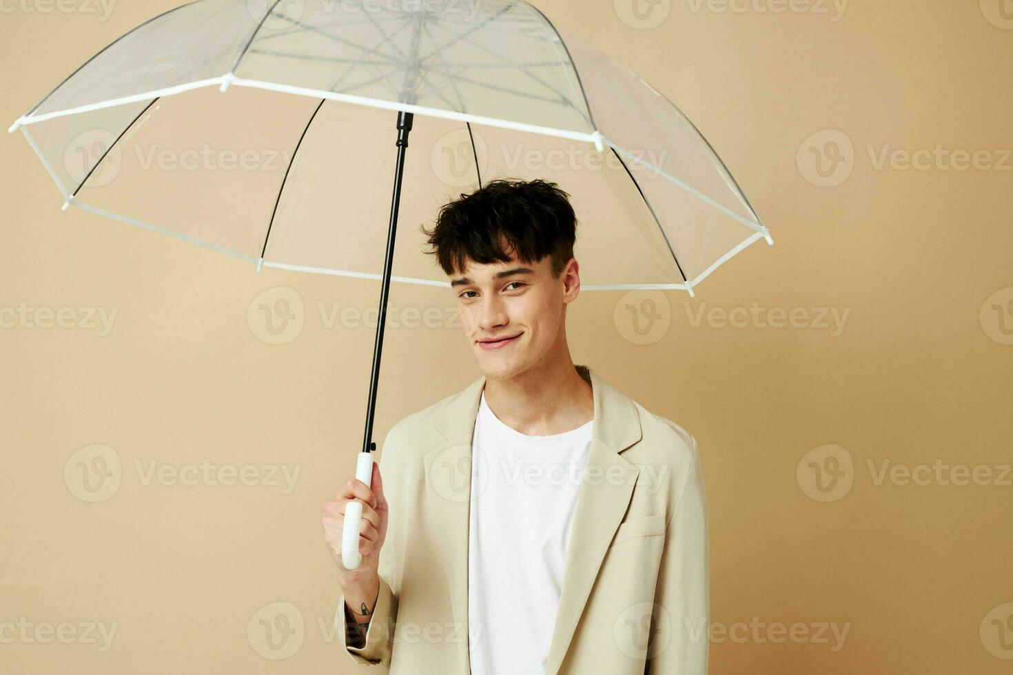 photo of a young guy in a white jacket with an open umbrella