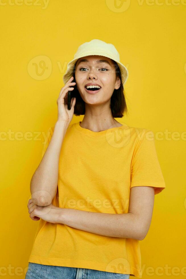 optimistic young woman in yellow t-shirt posing fashion in panama isolated background photo