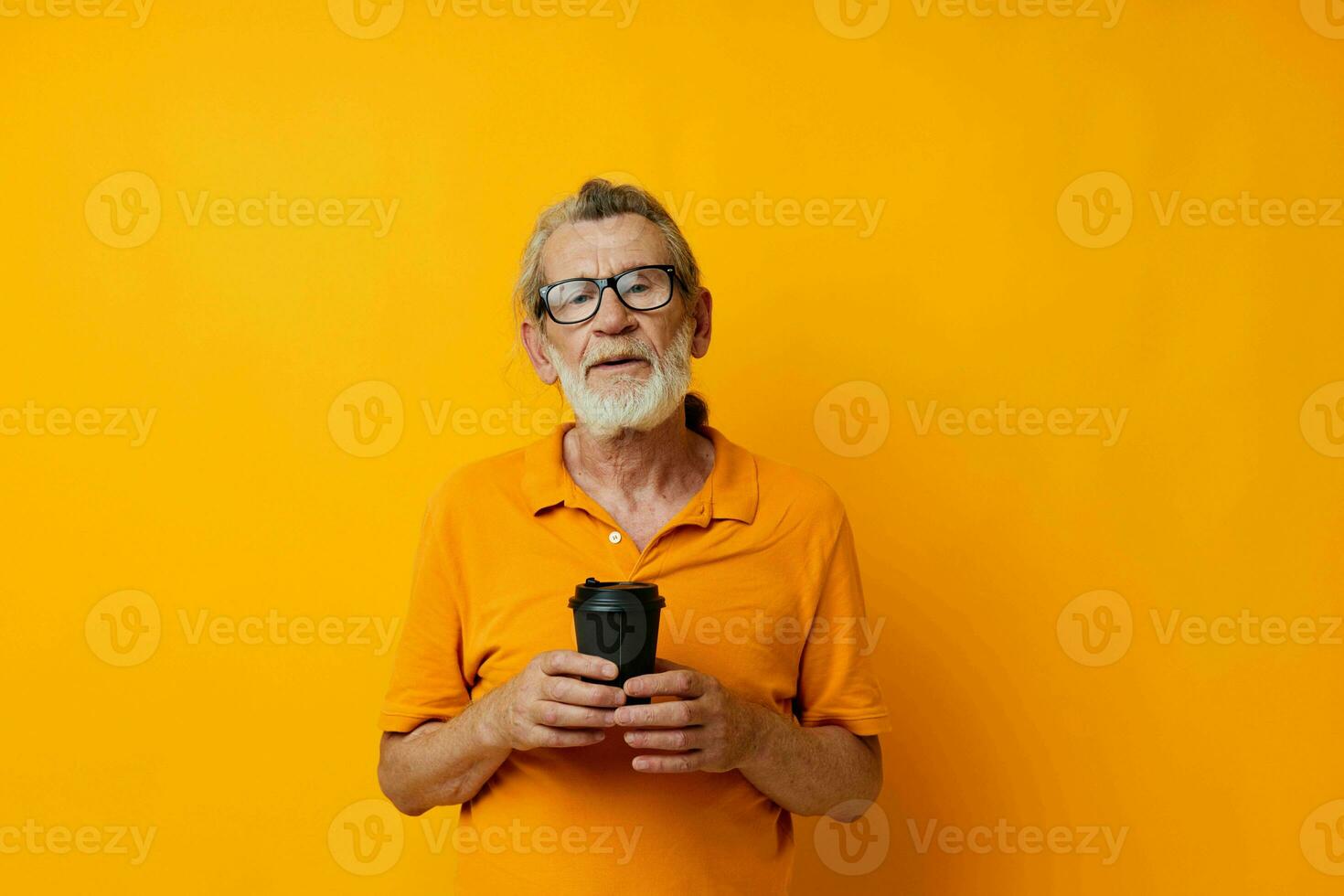 Portrait elderly man with black disposable cup yellow background photo