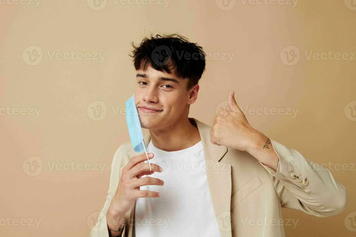 portrait of a young man in a medical mask in the hands of posing fashion isolated background unaltered photo