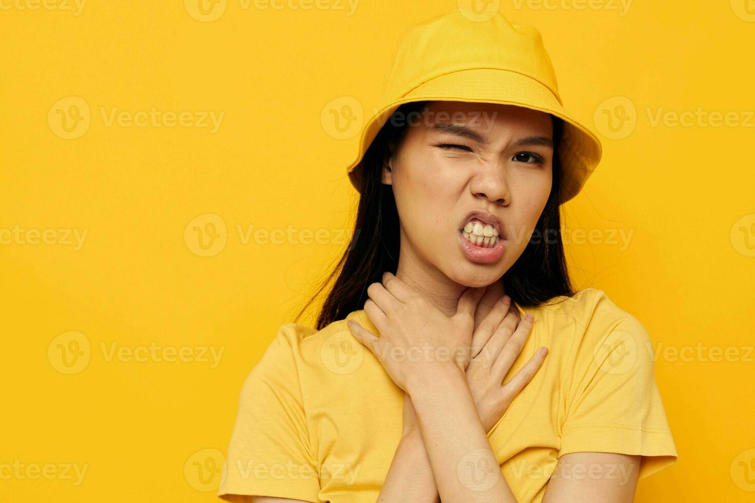 Charming young Asian woman wearing a yellow hat posing emotions yellow background unaltered photo