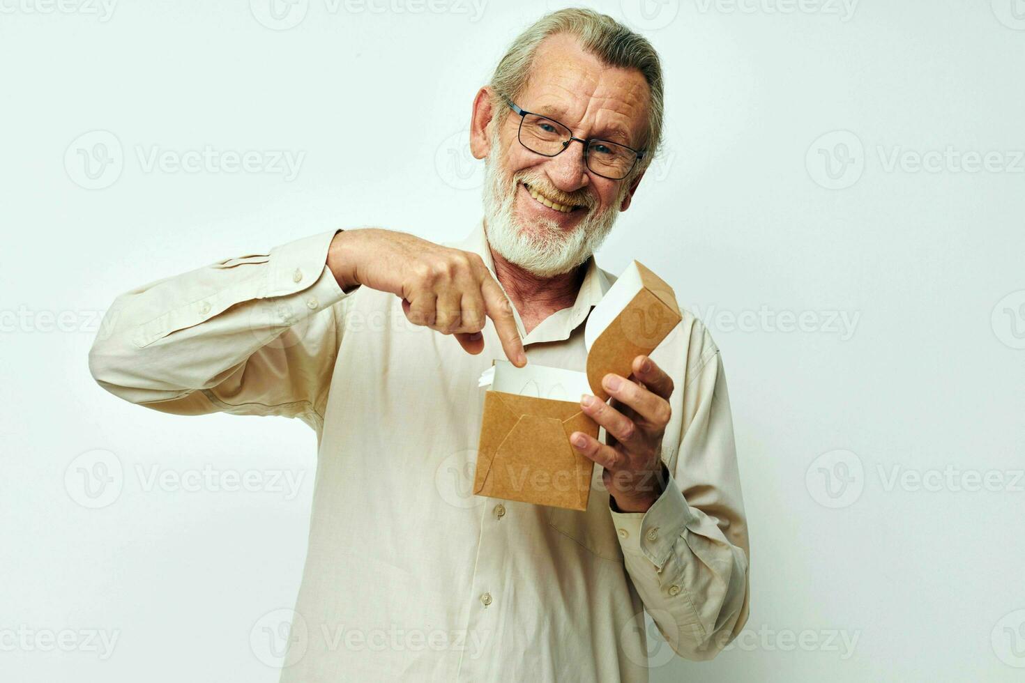 Old man with a box in his hands in studio alone photo