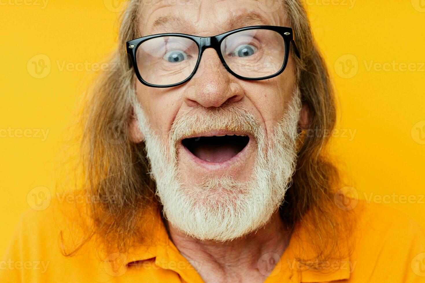 elderly gray-haired man with glasses face close-up yellow background photo