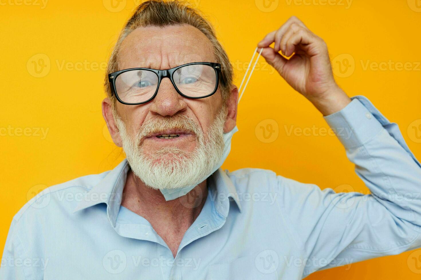 Portrait elderly man in medical mask protection yellow background photo