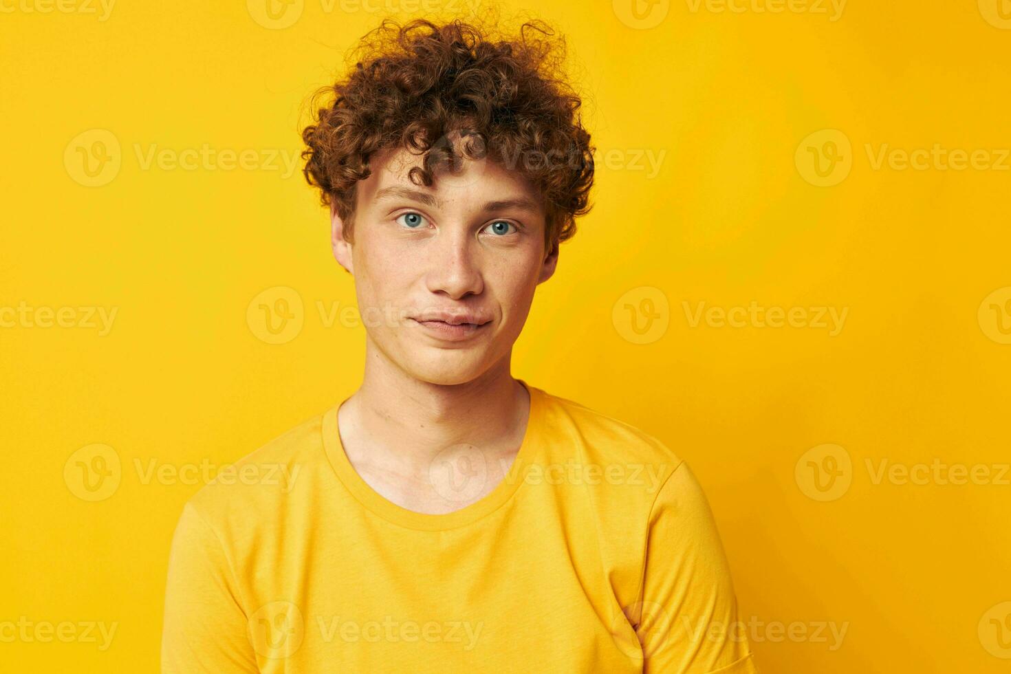 cute red-haired guy yellow t-shirt fashion hand gestures yellow background unaltered photo