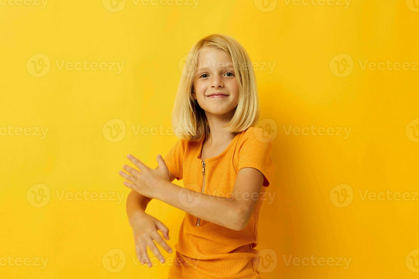 kid girl in a yellow t-shirt smile posing studio color background unaltered photo
