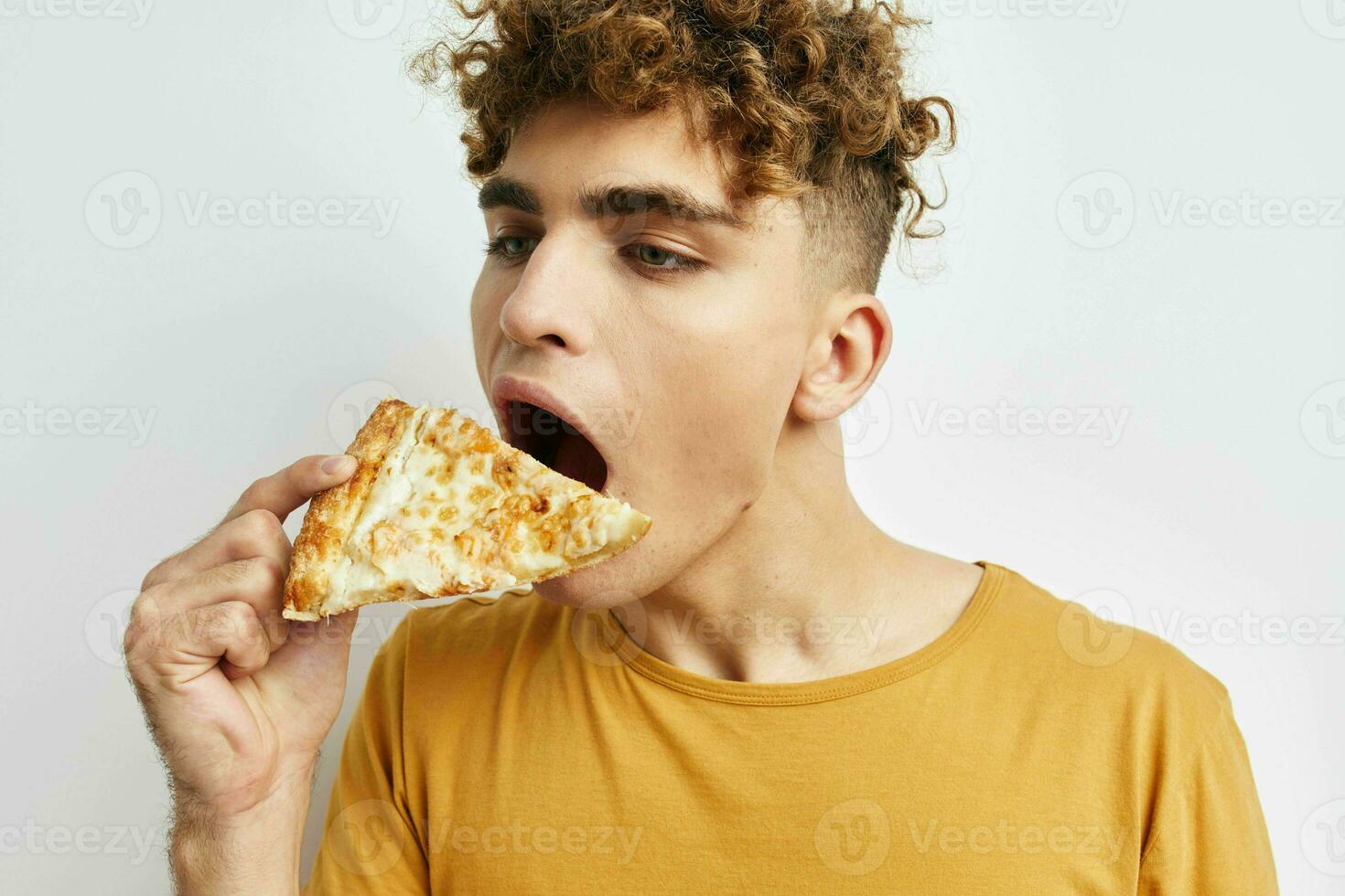 hermoso joven hombre comiendo Pizza posando de cerca estilo de vida inalterado foto