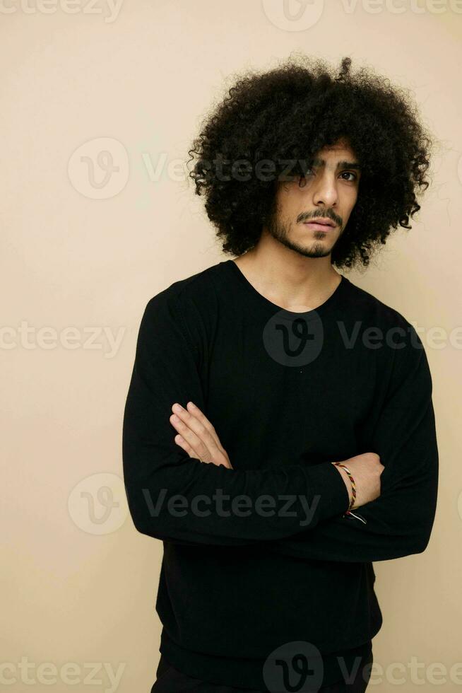 man with curly hair in a black sweater hand gesture isolated background photo