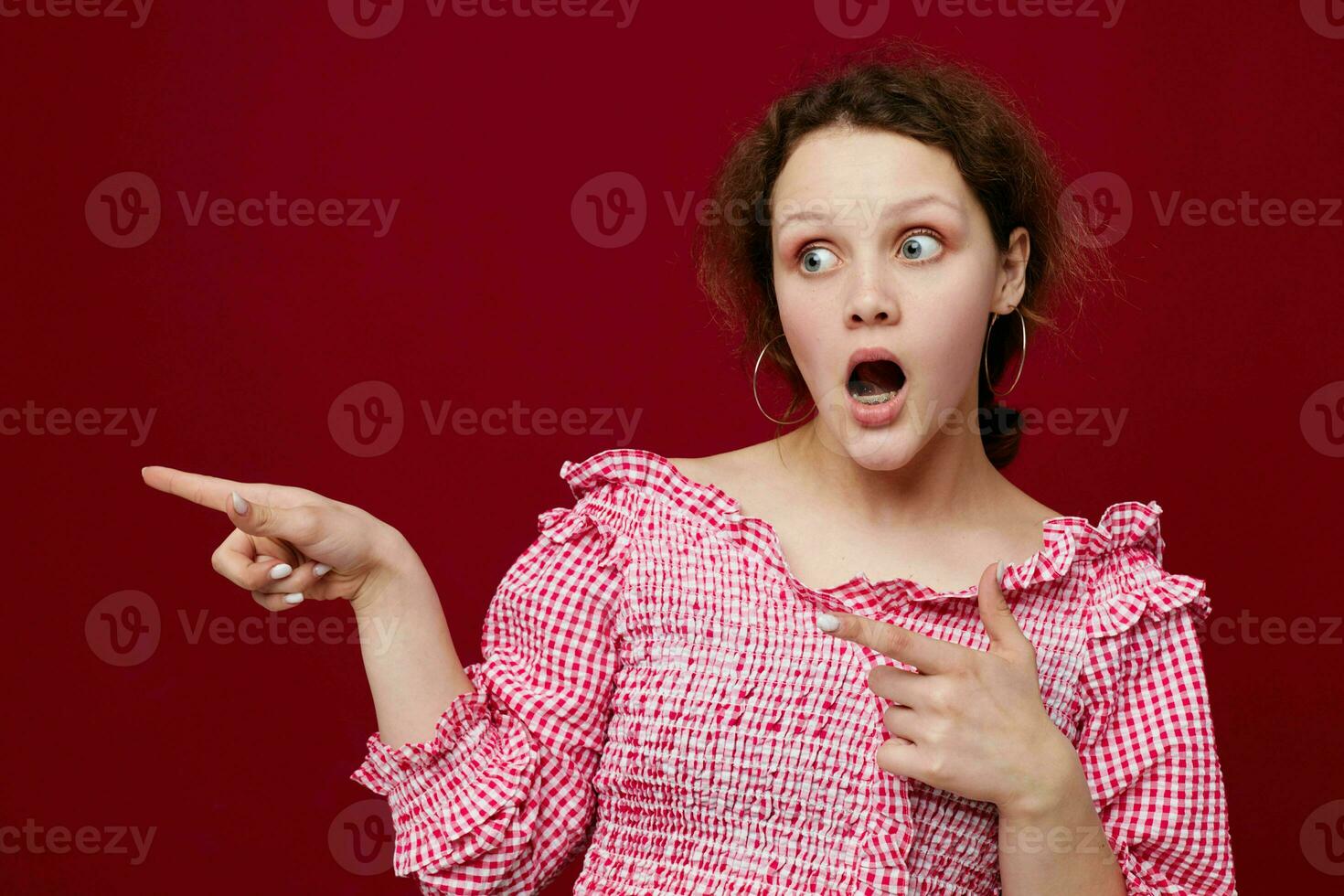 emotional woman in shirt posing studio red background photo