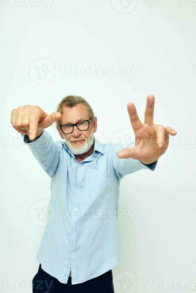 Senior grey-haired man in shirt and glasses posing emotions light background photo