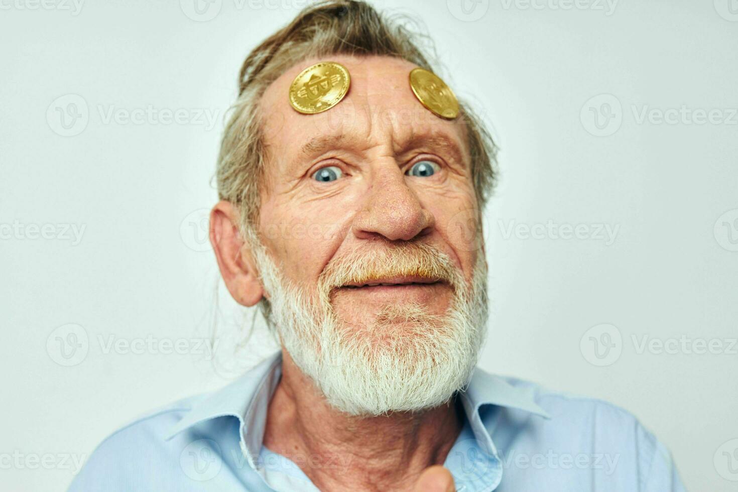 Photo of retired old man in a blue shirt bitcoins on the face isolated background