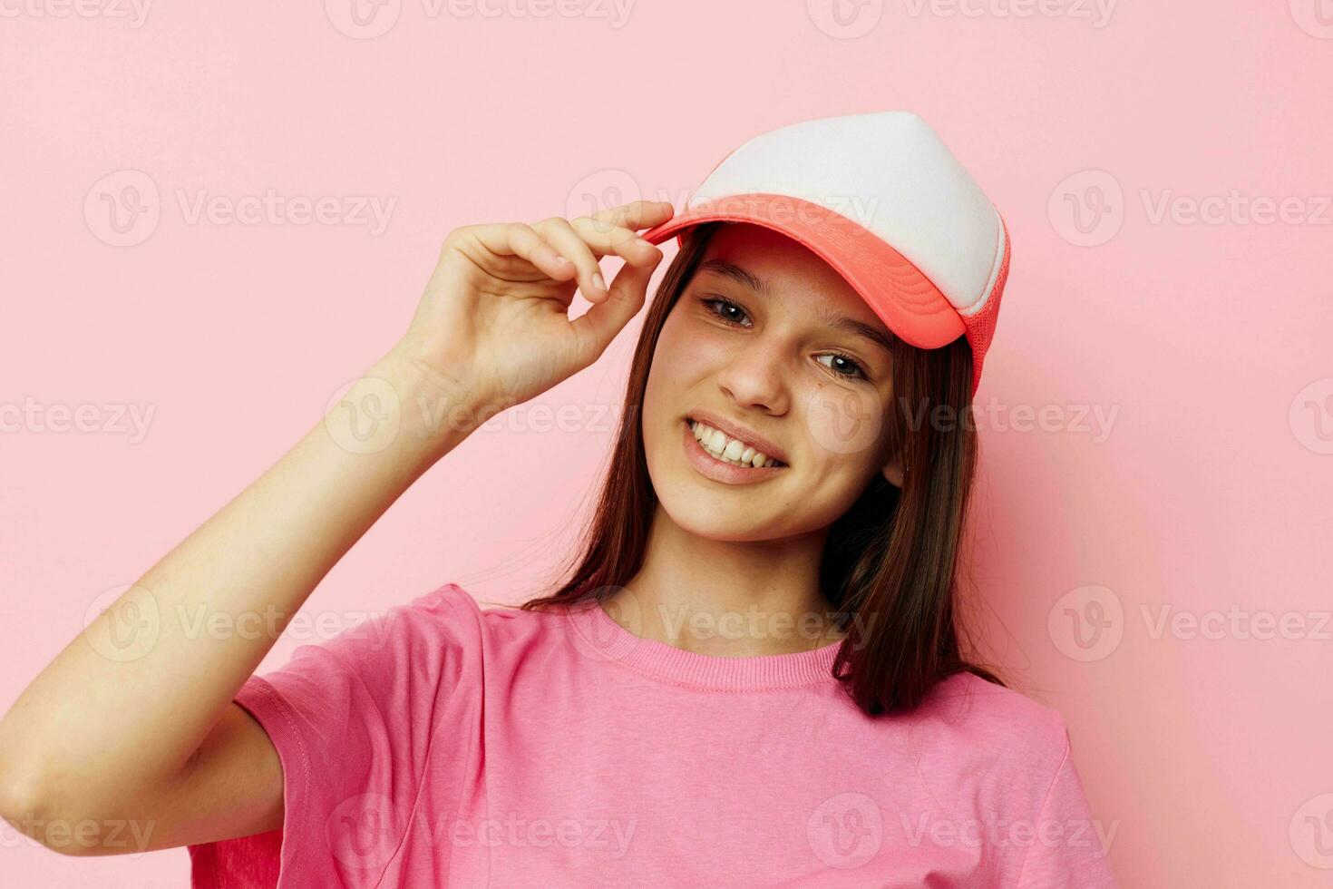 alegre joven niña con un gorra en su cabeza en un rosado camiseta foto