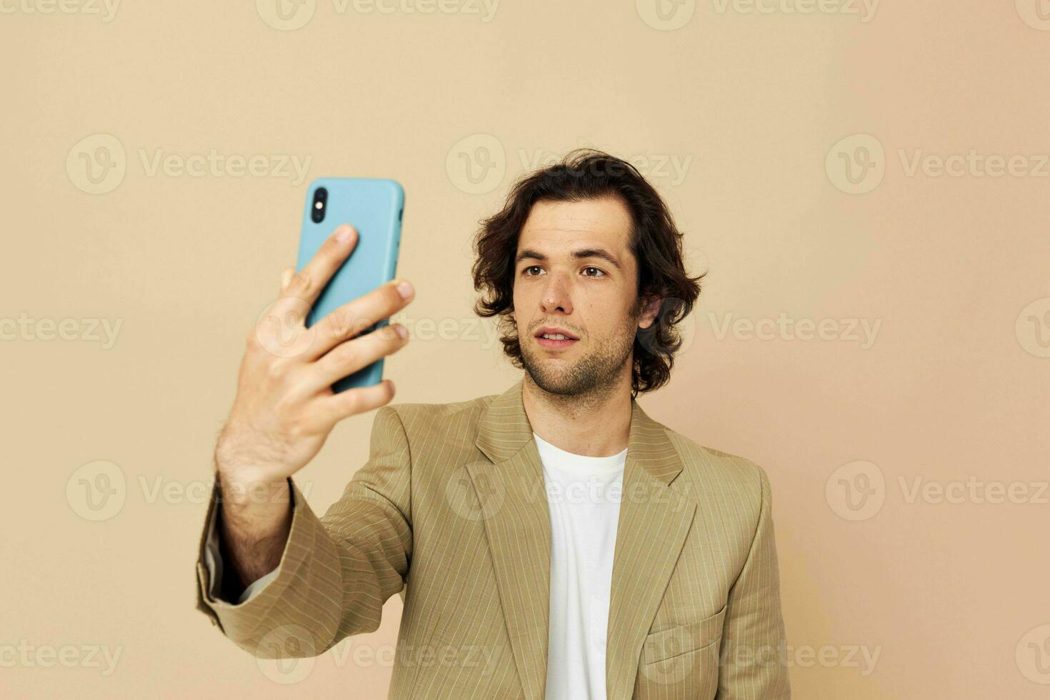 Attractive man with a phone in hand beige suit elegant style Lifestyle unaltered photo