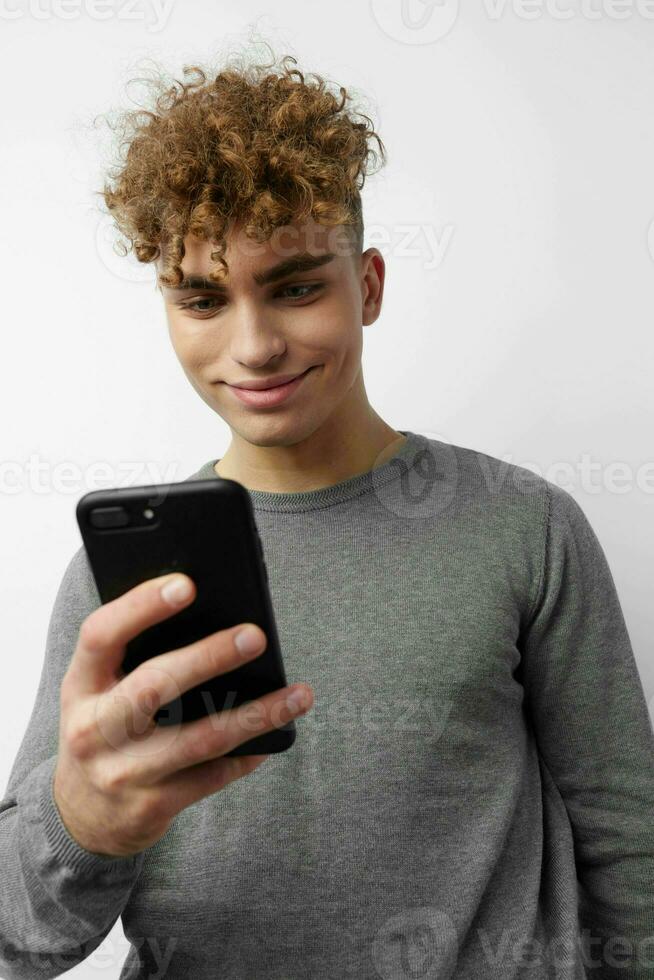 handsome young man looking at the phone fashion light background photo