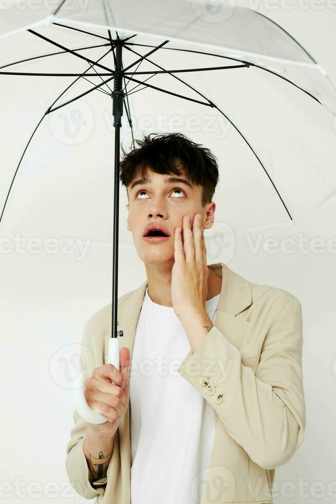 handsome guy transparent umbrella a man in a light jacket isolated background unaltered photo
