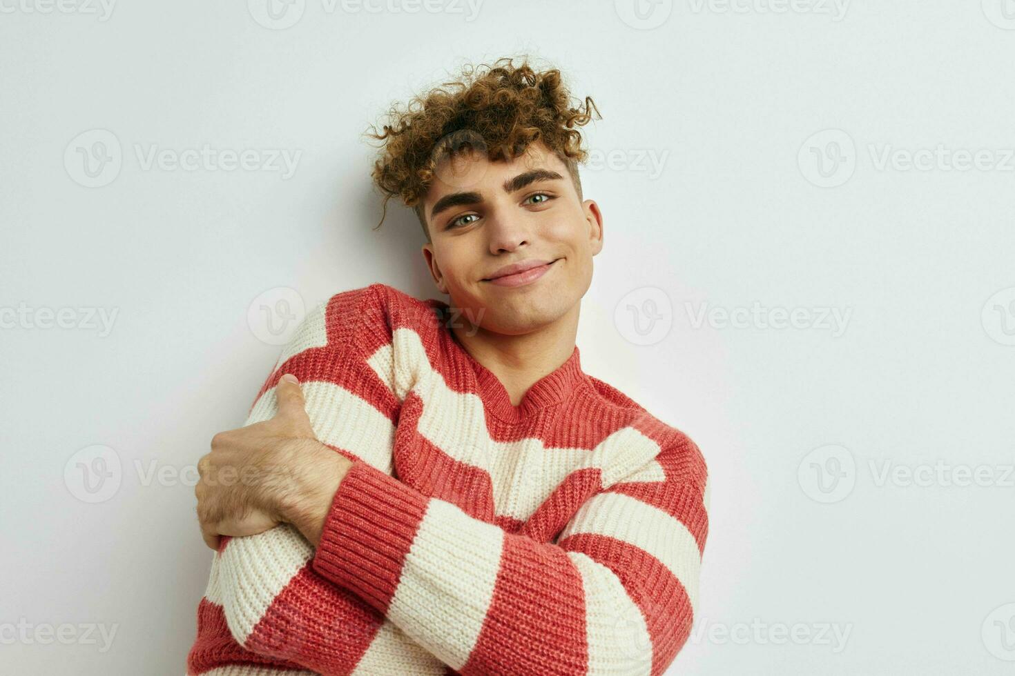 handsome guy in a striped sweater posing light background photo