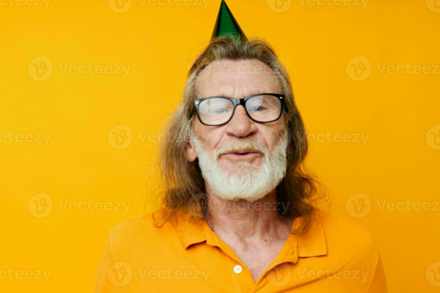 Portrait elderly man in a yellow t-shirt with a cap on his head fun yellow background photo