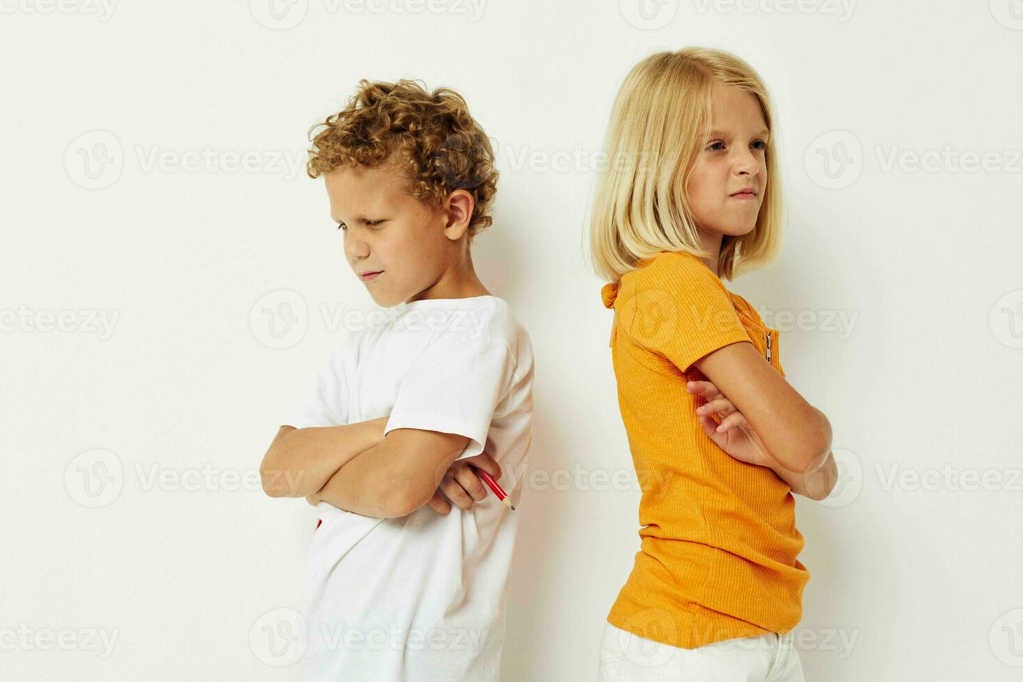 Cheerful boy and girl stand side by side posing light background photo