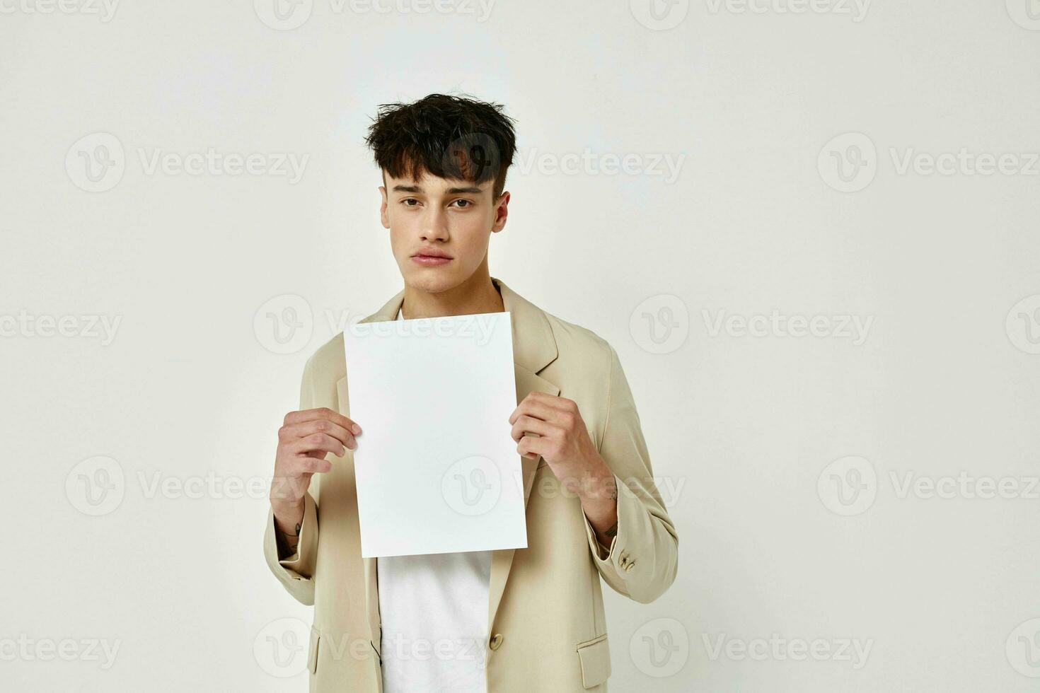 portrait of a young man in a beige suit copy-space notebook light background unaltered photo
