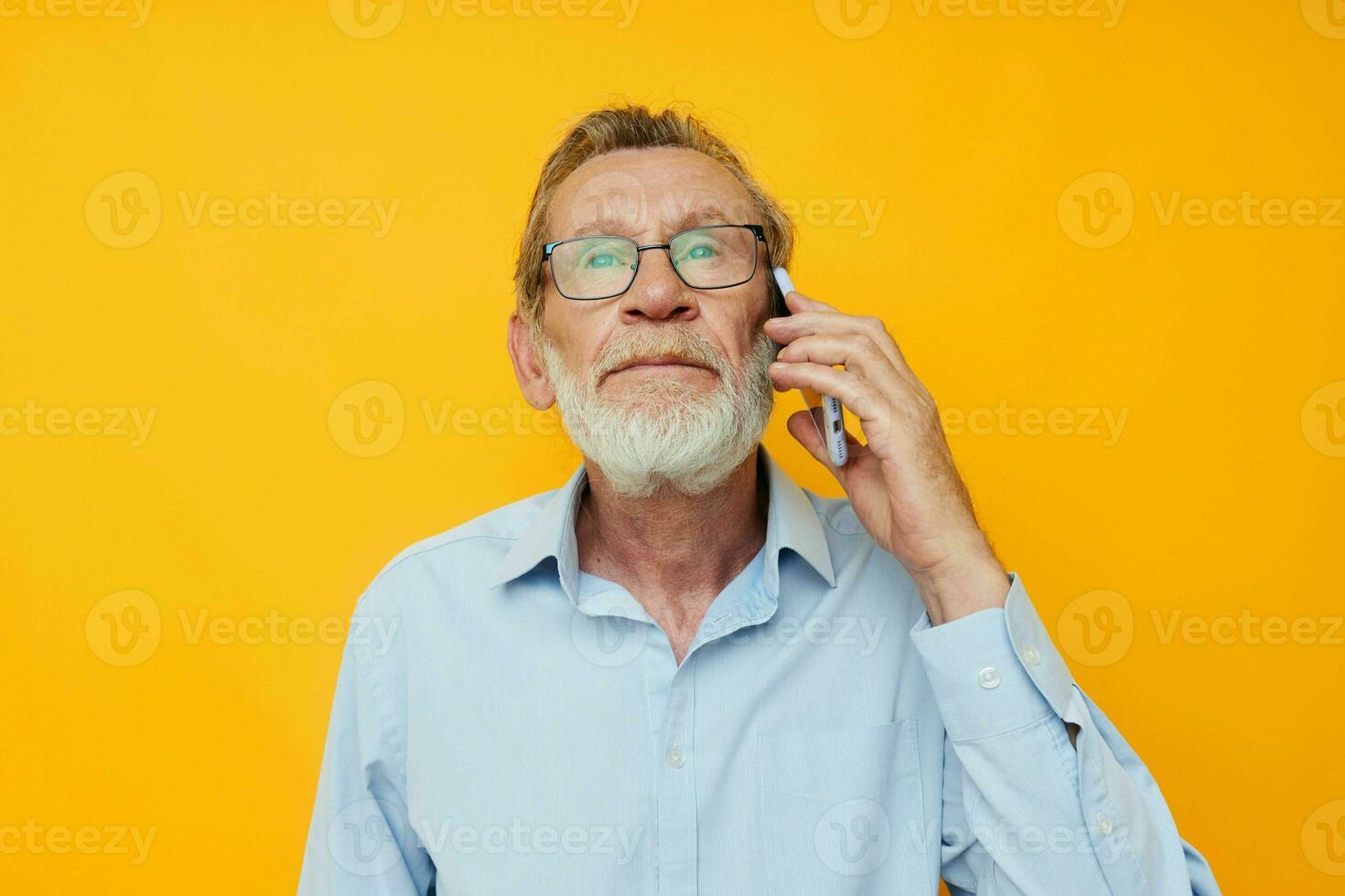 old man gray beard with glasses talking on the phone isolated background photo