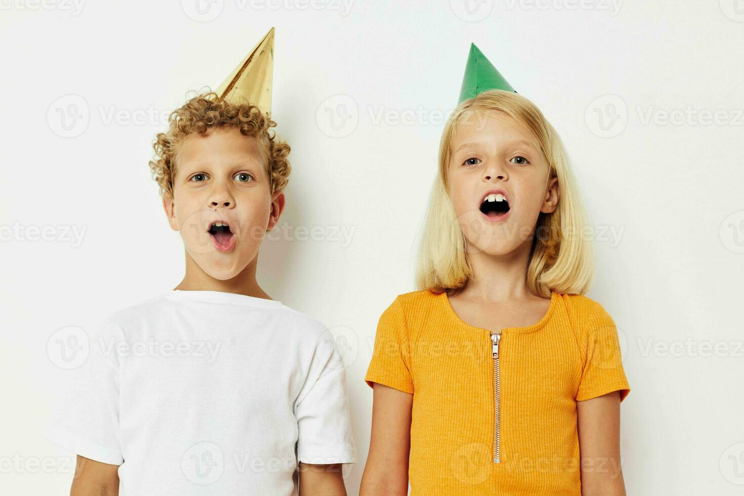 Boy and girl posing emotions holiday colorful caps isolated background unaltered photo