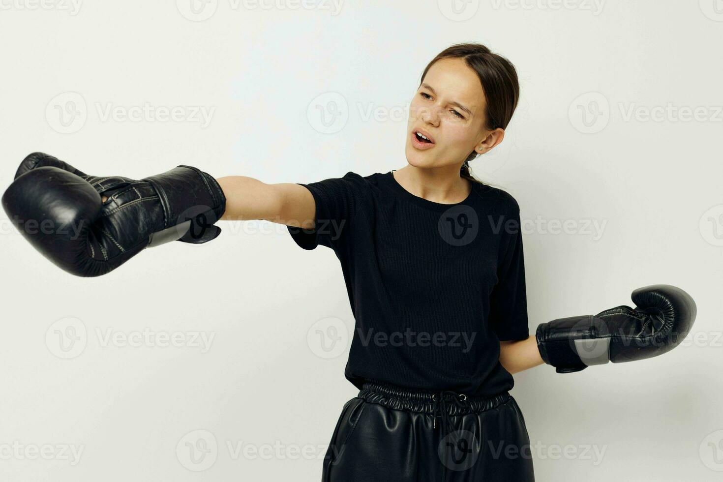 beautiful girl in black sports uniform boxing gloves posing isolated background photo