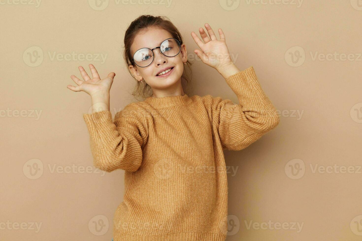 Portrait of happy smiling child girl with glasses emotions gesture hands Lifestyle unaltered photo