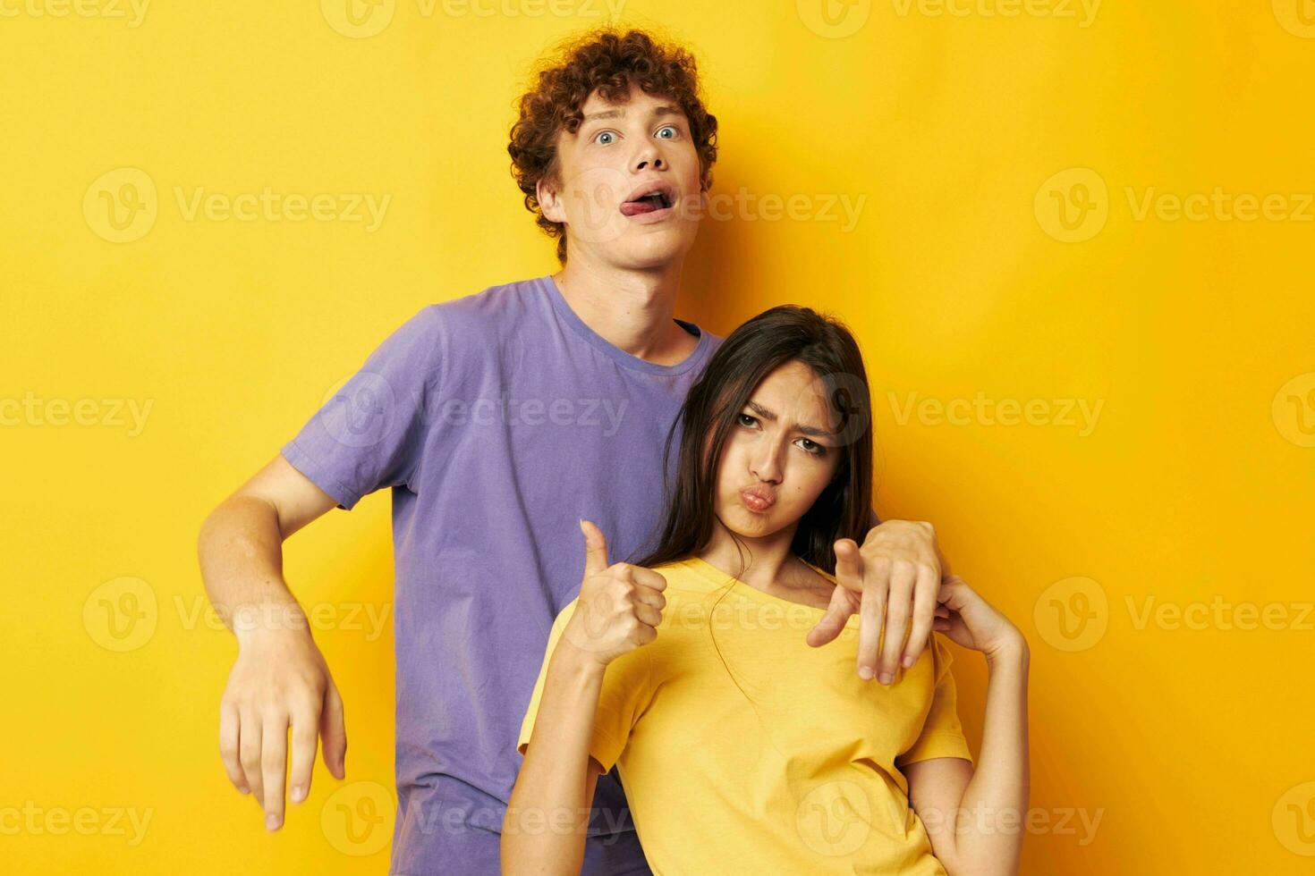 portrait of a man and a woman casual clothes posing emotions antics yellow background unaltered photo