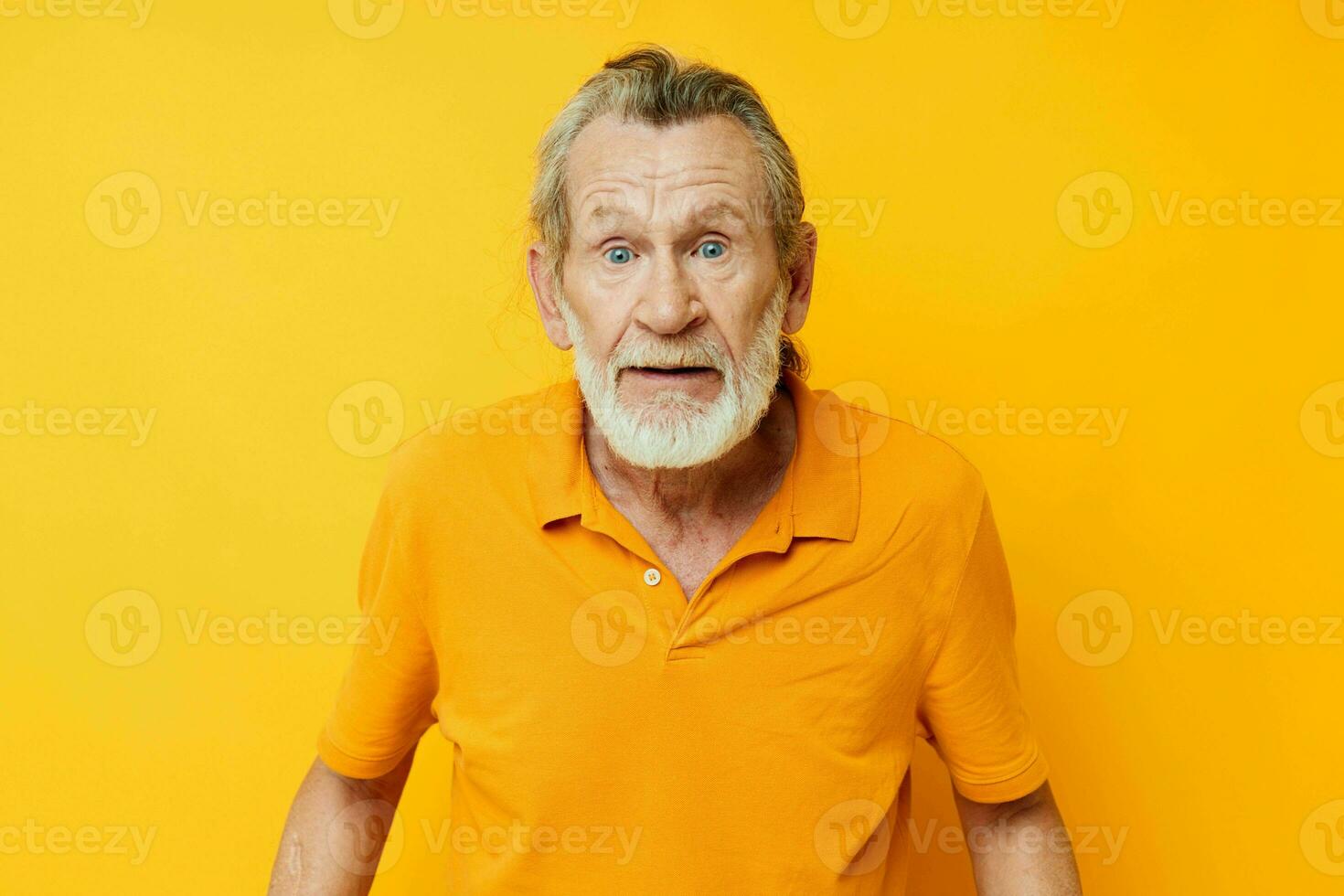 Senior grey-haired man yellow shirt posing emotions isolated background photo