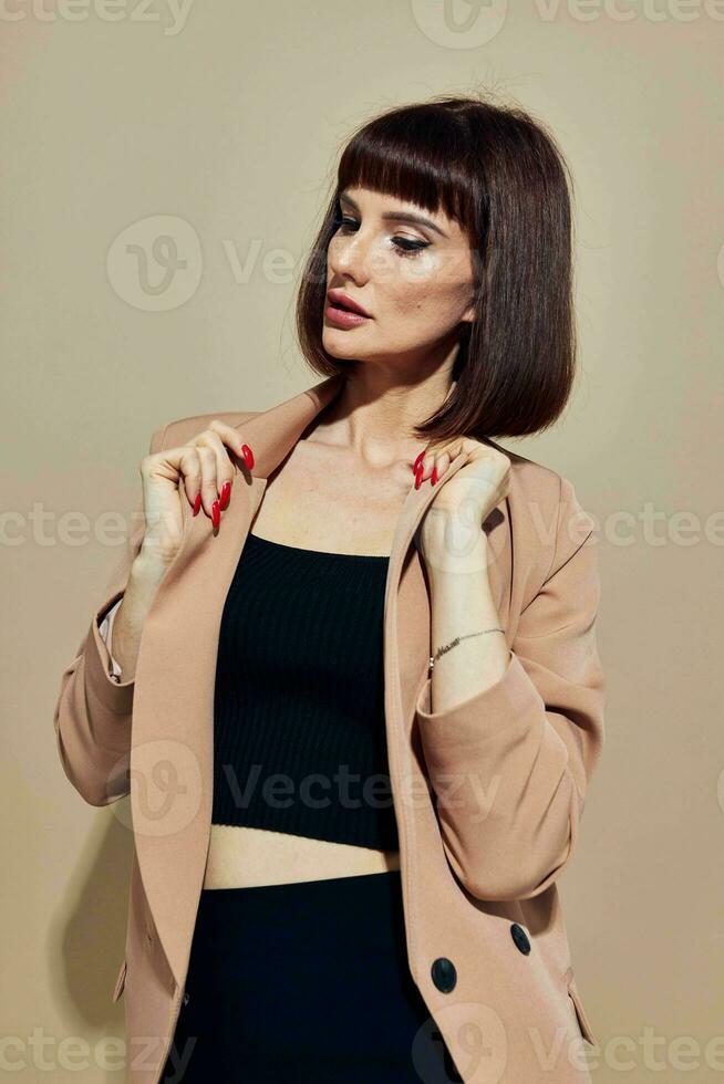 hermosa mujer en un beige chaqueta elegante estilo posando ligero antecedentes foto