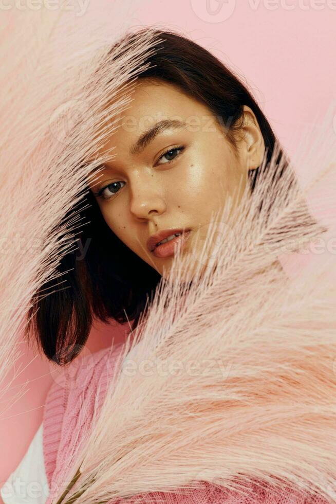 optimistic young woman in a pink vest with feathers in his hands Lifestyle unaltered photo