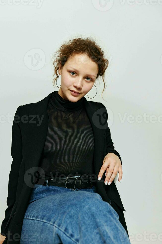 cheerful woman black jacket jeans posing light background unaltered photo