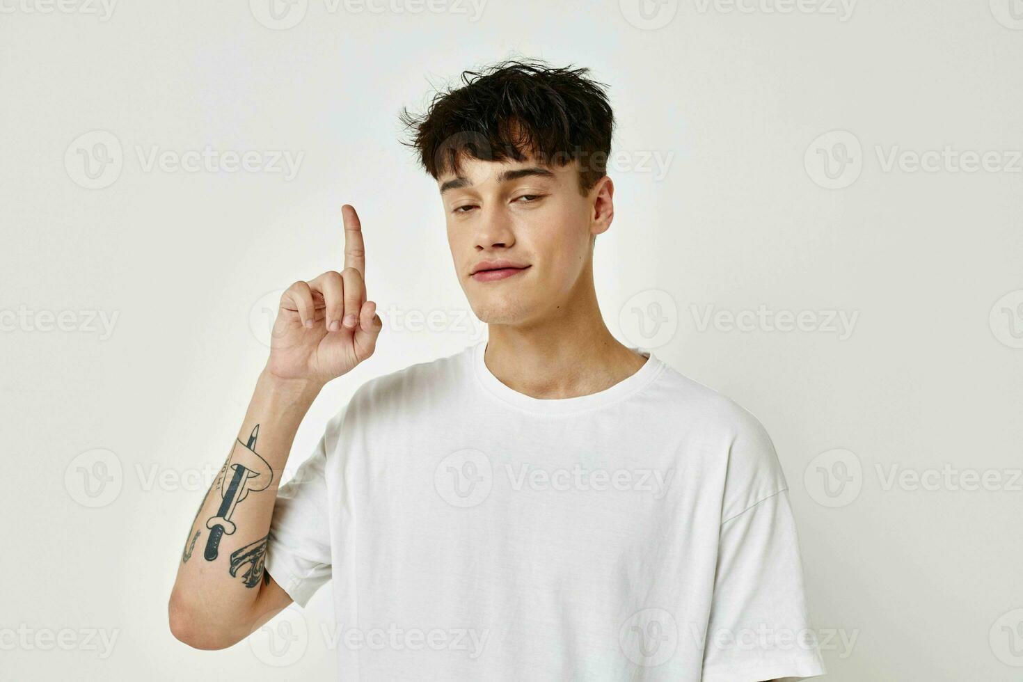 Man modern youth style white t-shirt tattoo on the arm model studio photo