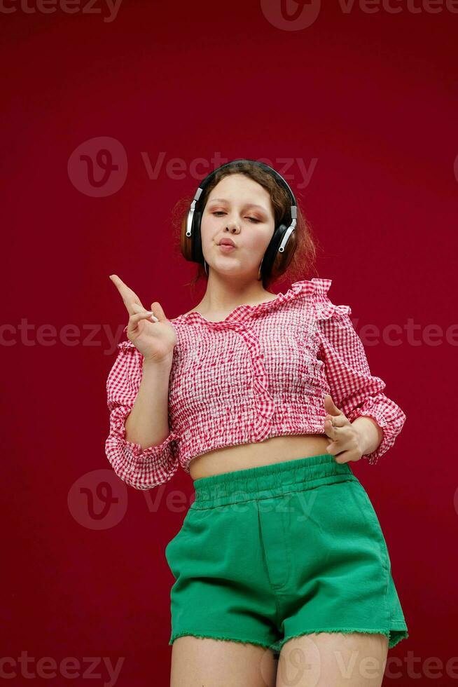 pretty girl in green shorts moves in headphones listening to music photo