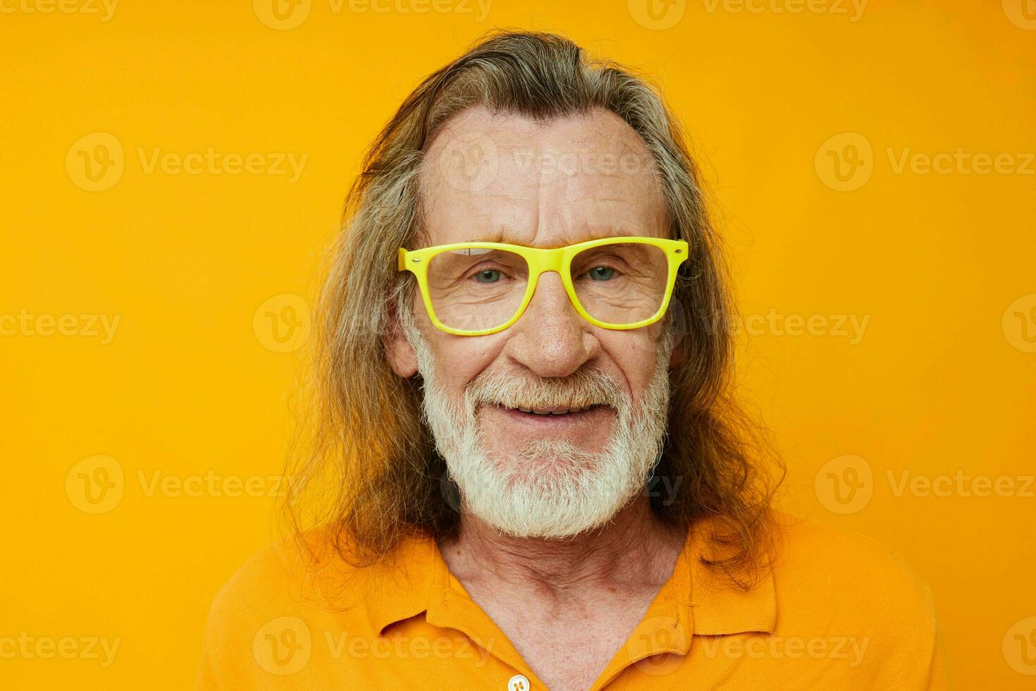 Portrait elderly man yellow t-shirt and glasses posing isolated background photo