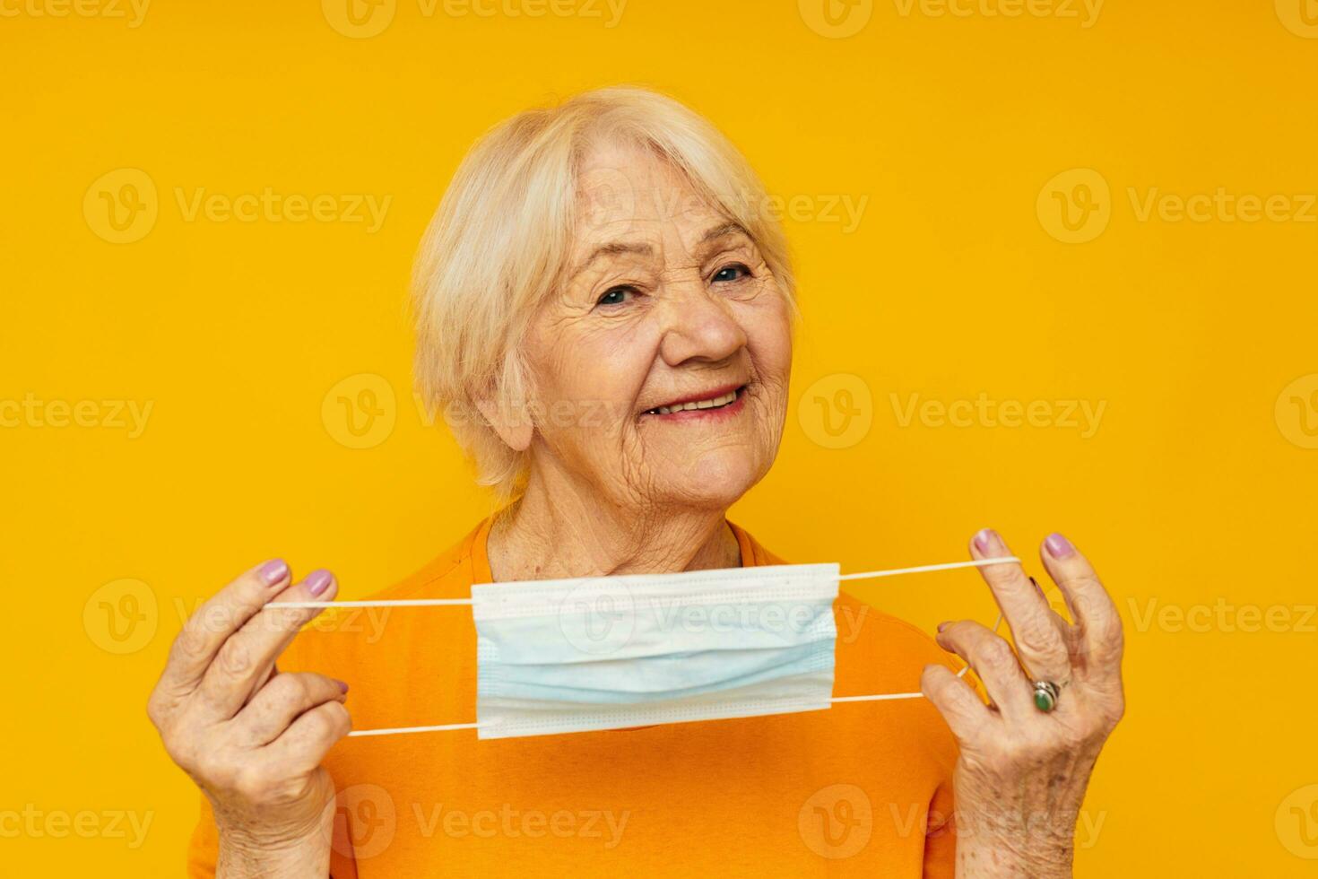 Photo of retired old lady in casual t-shirt medical mask close-up emotions