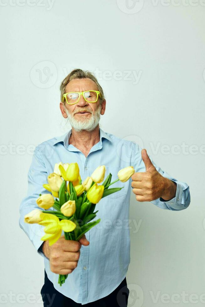foto de retirado antiguo hombre un ramo de flores de flores con lentes como un regalo ligero antecedentes