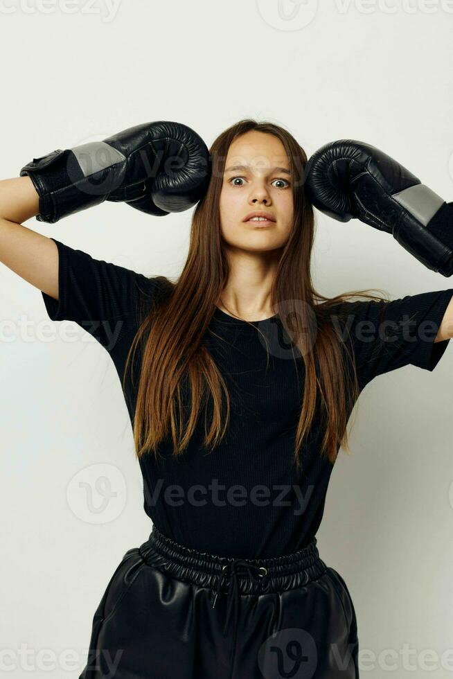 beautiful girl in boxing gloves punch in black pants and a T-shirt fitness training photo