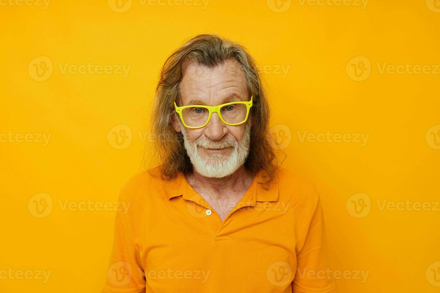 Photo of retired old man yellow t-shirt and glasses posing yellow background