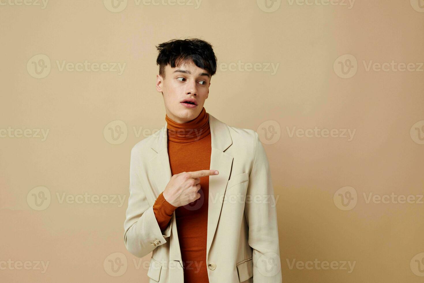 A young man posing with a phone in his hands in a jacket elegant style Lifestyle unaltered photo