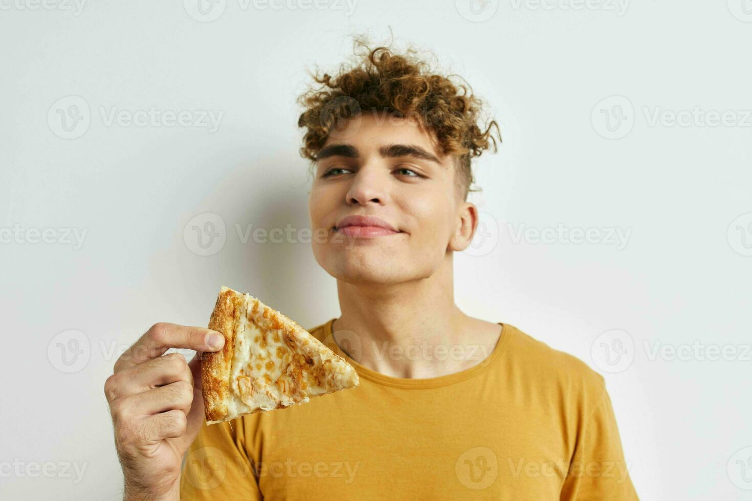 handsome young man eating pizza posing close-up Lifestyle unaltered photo